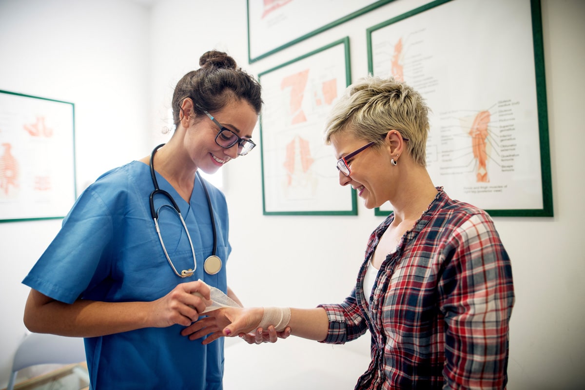 Nurse dressing complex wound of patient